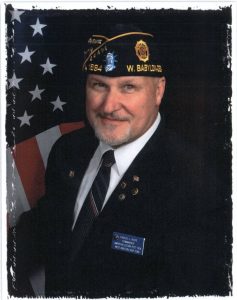 a man in military uniform standing in front of an american flag