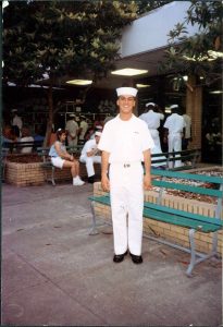 a man in military uninform standing by a bench