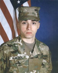 a man in military uninform standing behind a american flag