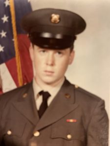 a man in a military uniform standing in front of a flag