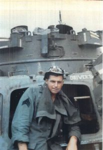 a man in military uniform standing in front of a military vehicle