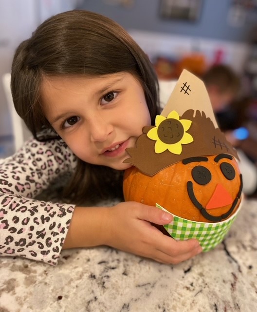 a child holding a decorated pumpkin