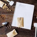 spring garden preparation for sowing vegetable seeds and planning. Pumpkin, coriander with labels, peat pots and tools on note book. Seasonal garden work.