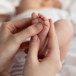 Closeup Shot Of Caring Mother Massaging Her Newborn Baby’s Foot