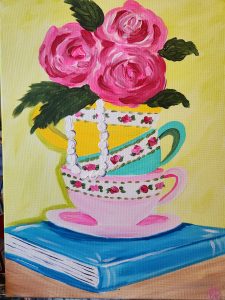 A painting of three teacups (yellow, blue, and pink) stacked on top of each other and sitting on top of a blue book with 3 pink roses in the top cup.
