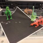 toy dinosaurs on photo copy machine