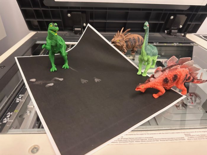 toy dinosaurs on photo copy machine