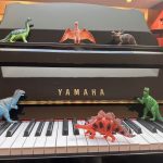 toy dinosaurs on piano keys