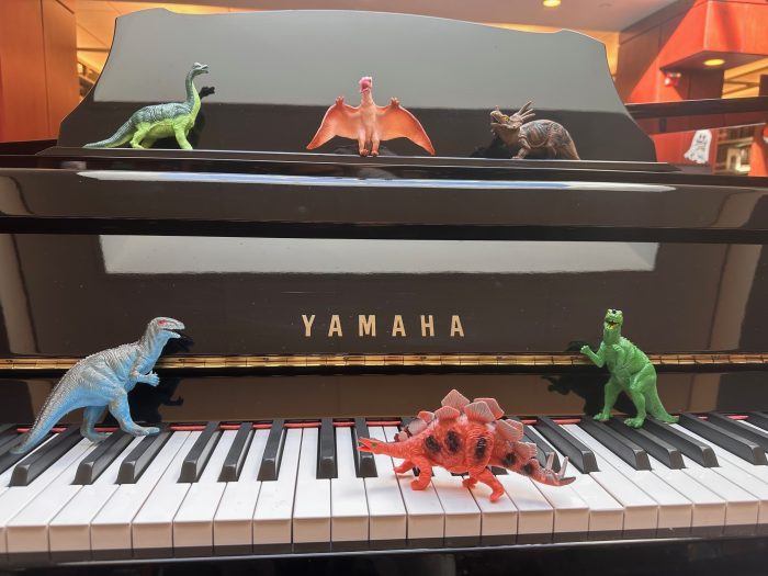 toy dinosaurs on piano keys