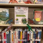 toy dinosaurs on sustainability shelf in library