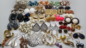 Rows of earrings and other jewelry sitting on a table.