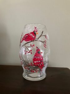 A blizzard vase decorated with red cardinals sitting on a branch.