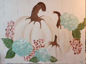 Three white pumpkins of varying sizes with light blue hydrangeas, green leaves, and pale red berries around them.