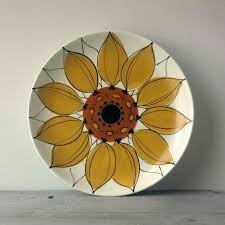 A large white plate with a sunflower painted on it.