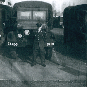 a man in a military uniform standing in front of military vehicle