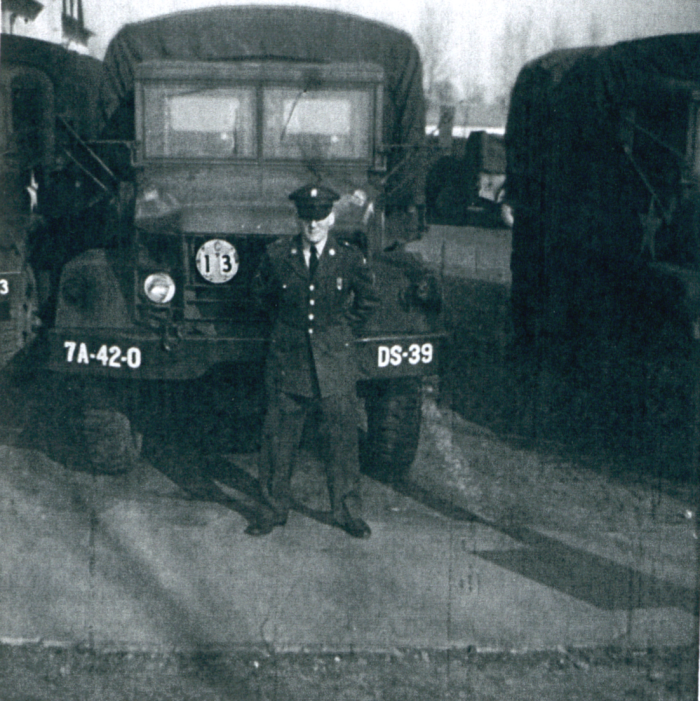 a man in a military uniform standing in front of military vehicle