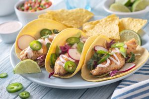Delicious traditional spicy fish tacos with jalapeno, cilantro, cabbage and radish.