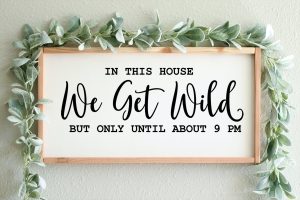 A sign with "In this house we get wild but only until about 9 pm".
