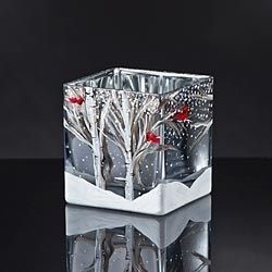 A square, glass candle holder painted with a winter theme of trees and snow.