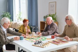 Group Of Elderly Friends Eating Pizza at The Table After