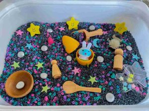 A bin full of sand, cheerios, and various toys to explore.
