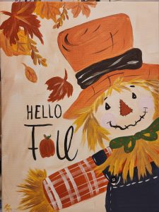 A painting of a scarecrow with Hello Fall next to it.