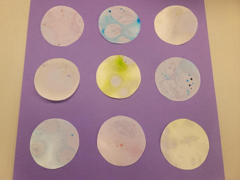 Nine slides with different patters on them laying on a table.